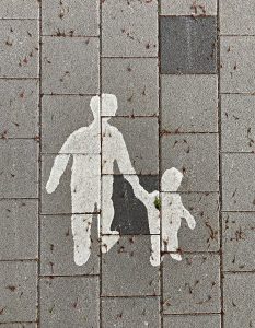 This photo shows a painting of a parent walking beside their child. Parents and caregivers have a key role in the development of a child.