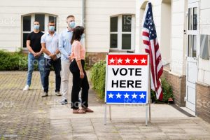 People waiting in line to vote with masks on