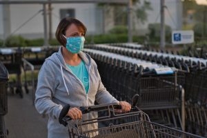 Woman wearing a mask pushing a shopping cart