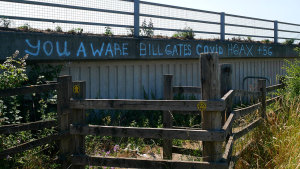 COVID-19 conspiracy graffiti on a bridge. "You aware Bill Gates COVID Hoax +36"