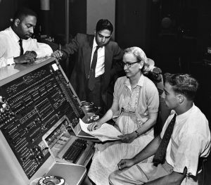 Grace Hopper is pictured with three other men around a computer
