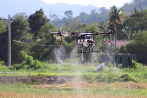 Image of a drone spraying mist over a field